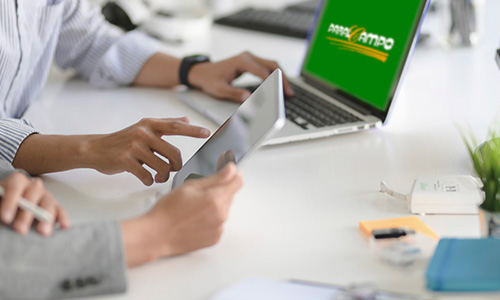 Administración Dos personas trabajando con una tablet y ordenador